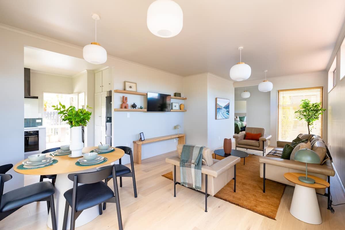 Bright open-plan living and dining room at Nelson Bridge House with oak floors and sage accents