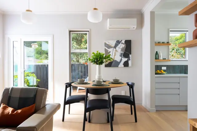 Round dining table for four beside the garden doors