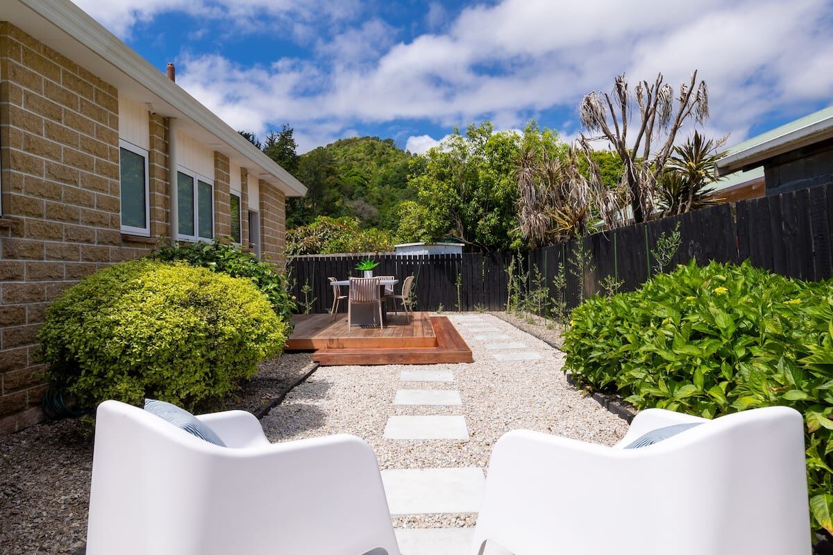 Private garden courtyard at Nelson Bridge House with outdoor chairs and a stepping-stone path