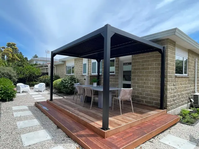 Timber deck with pergola and outdoor dining table in the garden