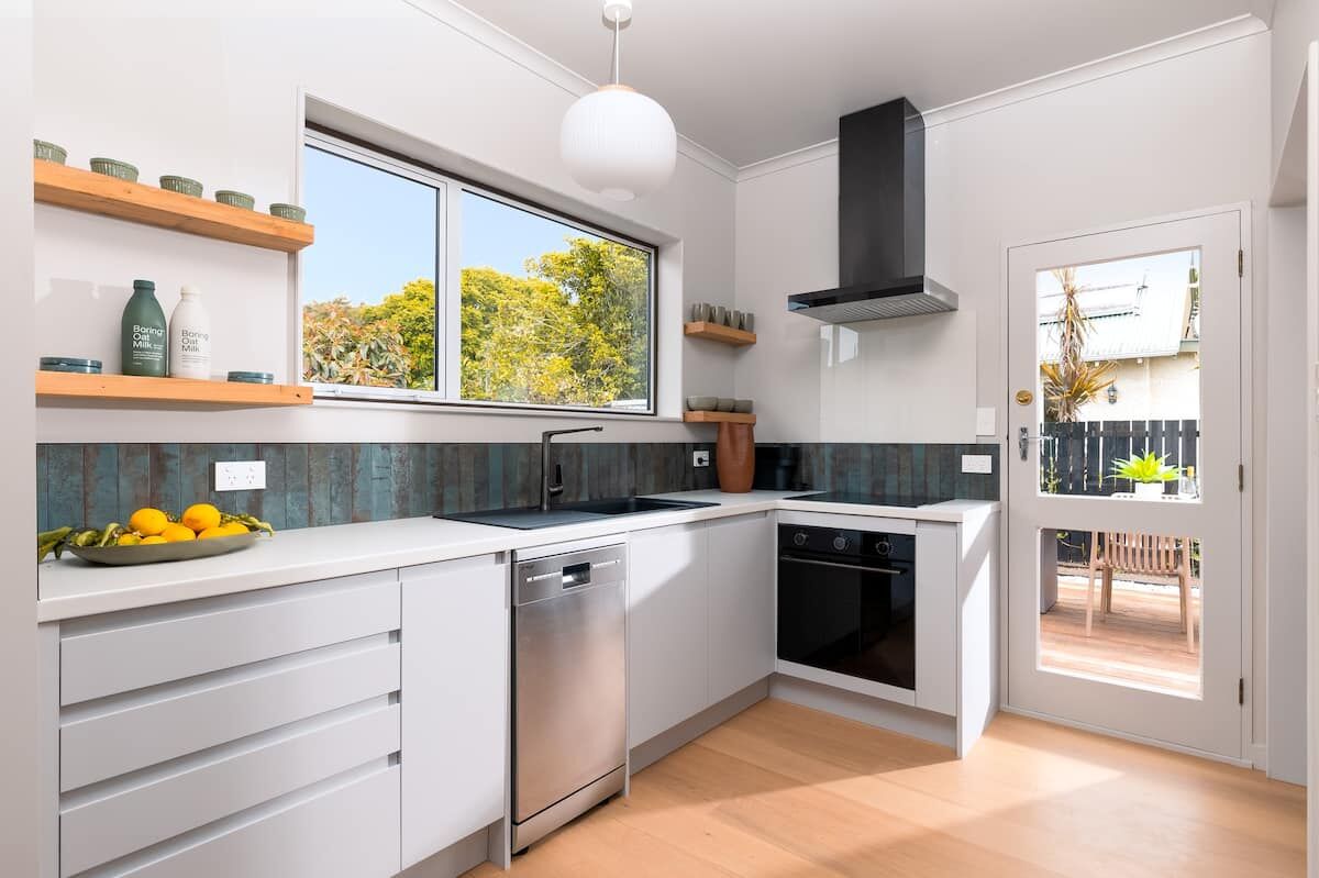 Modern kitchen at Nelson Bridge House with dishwasher, oven and induction cooktop
